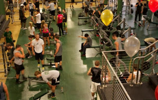 Overhead photo of many people working out in a crowded public gym.