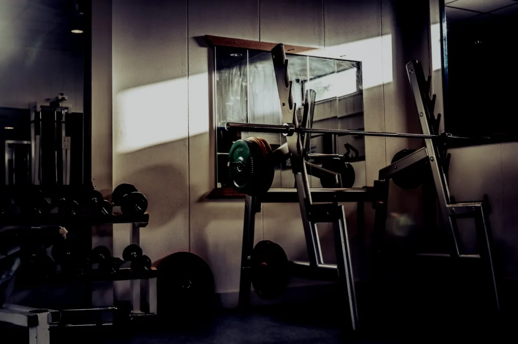 Artistic photo of a garage gym with a squat and weight rack.