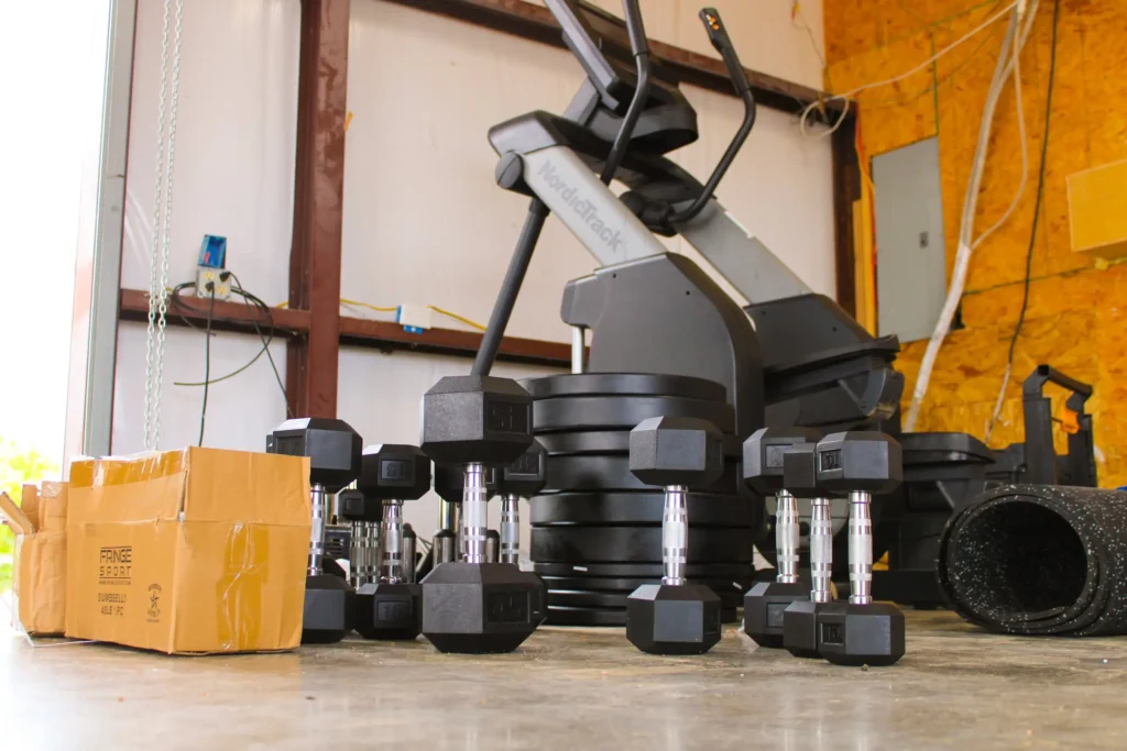 Build process of a custom home gym – weights on the floor of a garage.