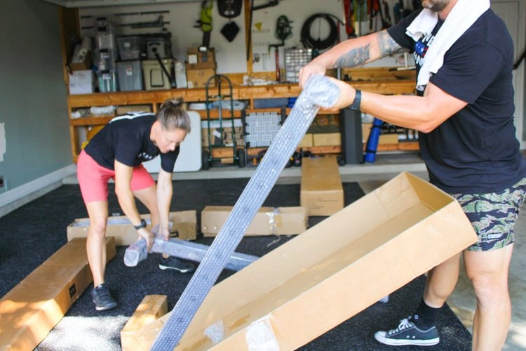 Two members of the Lonestar Gym Builders team building a custom home gym.