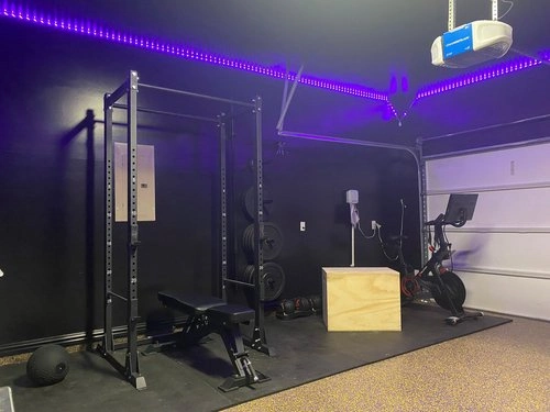Small garage gym setup with purple LED lighting.
