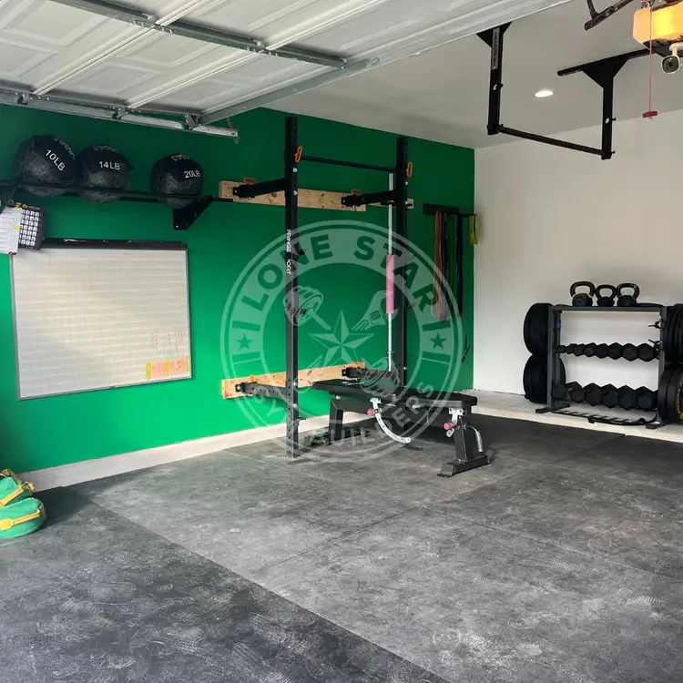 Custom-built garage gym with a green wall.