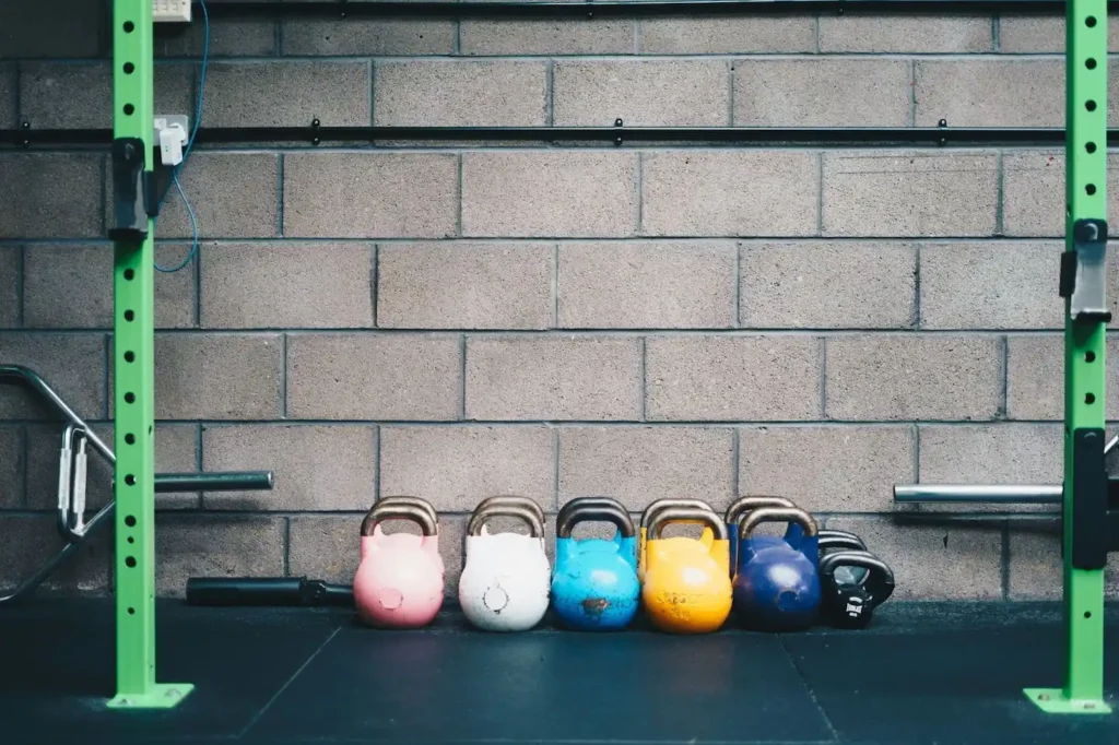 Five sets of kettlebells on the floor of a custom home gym.